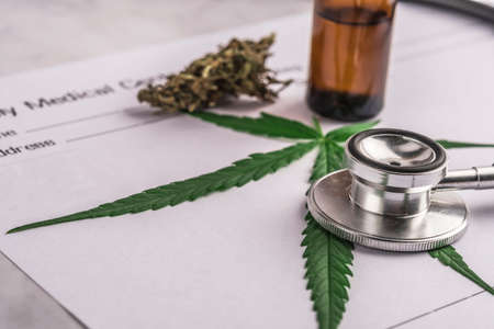 Assorted cannabis products, pills and cbd oil over medical prescription sheet - medical marijuana concept.の写真素材