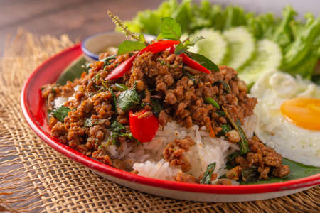 Rice topped with stir-fried pork, basil and fried egg. fried stir basilの写真素材