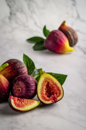 Half and whole figs on gray cement or stone background.の写真素材