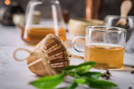 Hot tea in glass teapot and cup with steam on dark background.の写真素材