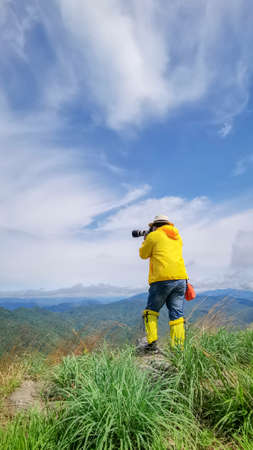 Tourists stand to take pictures at the viewpoint with mountains and beautiful skies, the rainy season of Southeast Asia.の写真素材