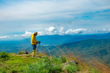 Tourists stand to take pictures at the viewpoint with mountains and beautiful skies, the rainy...