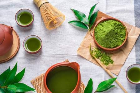 Green tea powder with leaf in ceramic dish on the table, Japanese wire whisk made of bamboo for...