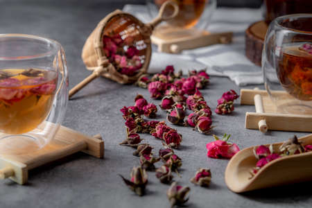 tea made from tea rose petals in a glass bowl on drak black rustic background, Concept tea time.の写真素材