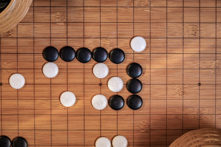 Go board game playing. A competitor is placing a marble piece on a Go board game, Hand playing black...