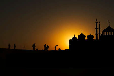 Islamic Arabic mosques sunset. black silhouettes cityscape mosques, minarets, Sunset clouds orange sky.Religion crescents. Architecture design, holiday Muslim design template.の写真素材