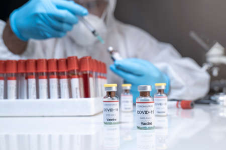 Concept fight against virus covid-19 corona virus, doctor or scientist in laboratory holding a syringe with liquid vaccines for children or older adults,Concept:diseases,medical care,science.の写真素材