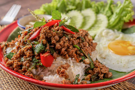 Rice topped with stir-fried pork, basil and fried egg. fried stir basilの写真素材