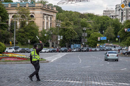 Kyiv / Ukraine - May 25, 2020: Traffic guard dressed as a police officer controls traffic with a wand on the European square in Kyivのeditorial素材