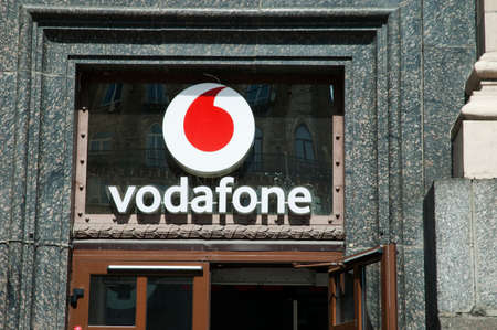 Kyiv / Ukraine - July 21, 2020: Nameplate of Vodafone mobile operator fixed on a glass doorのeditorial素材