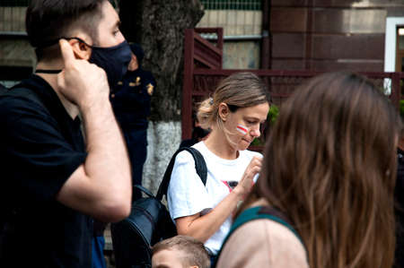 KYIV, UKRAINE - AUGUST 13, 2020: Activist woman with the flag of Belarus painted on the cheek in support of the protests in Belarus near the Embassy of Belarus in Kyiv demand the resignationのeditorial素材