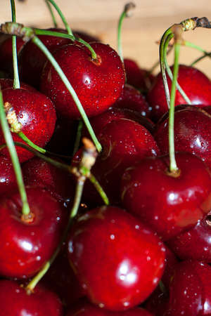 Fresh cherries in jar on the wooden background. Selective focus. Focus on the right cherries in front of jar.の写真素材