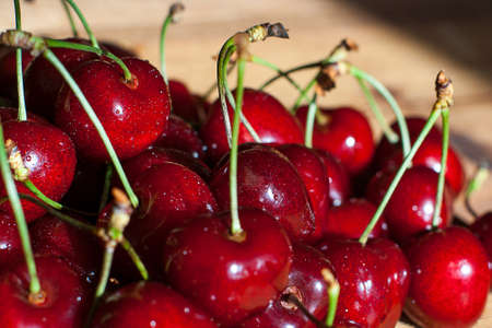 Fresh cherries in jar on the wooden background. Selective focus. Focus on the right cherries in front of jar.の写真素材