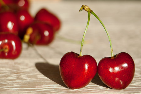 Fresh cherries in jar on the wooden background. Selective focus. Focus on the right cherries in...