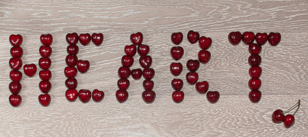 Fresh cherries in jar on the wooden background. Selective focus. Focus on the right cherries in...