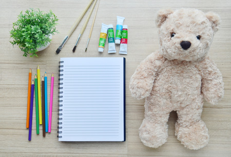 Artistic : Blank paper, color paint and bear doll on the wood table - Top viewの写真素材