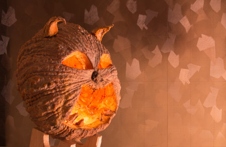 Halloween pumpkin with a light into the shadows, orange-yellow background.の写真素材