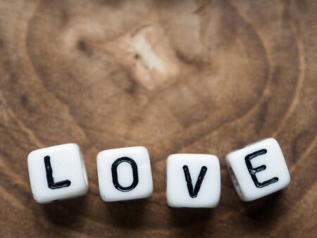 Letters spelling 'love' on wooden textured background.の写真素材
