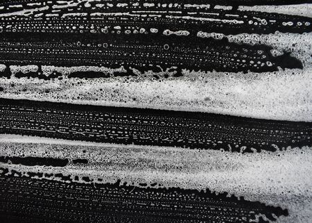 White soap bubbles on a black backgroundの写真素材