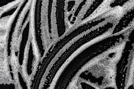 White soap bubbles on a black backgroundの写真素材