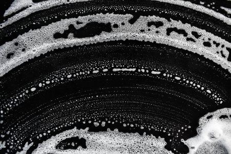 White soap bubbles on a black background