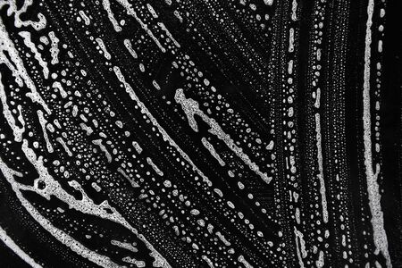 White soap bubbles on a black backgroundの写真素材