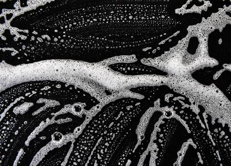 White soap bubbles on a black backgroundの写真素材