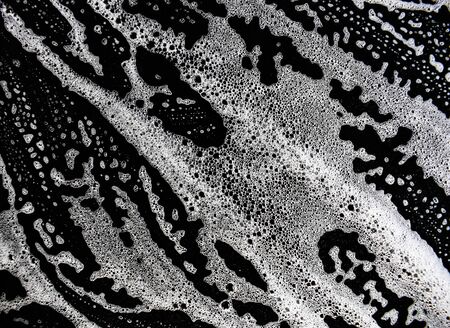 White soap bubbles on a black backgroundの写真素材