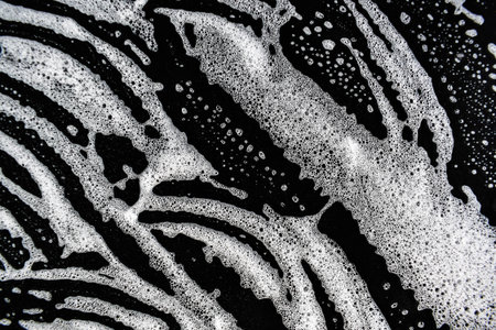 White soap bubbles on a black background