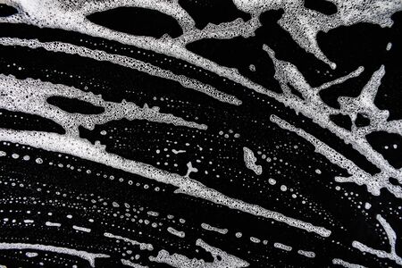 White soap bubbles on a black backgroundの写真素材