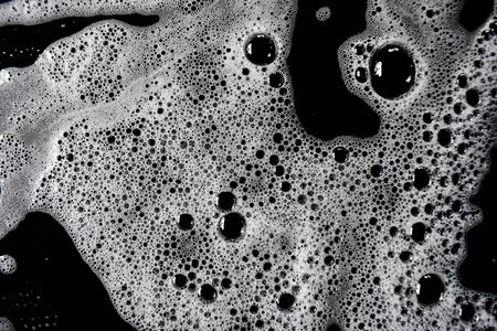 White soap bubbles on a black backgroundの写真素材
