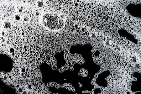 White soap bubbles on a black backgroundの写真素材