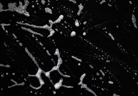 White soap bubbles on a black backgroundの写真素材