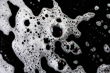 White soap bubbles on a black backgroundの写真素材