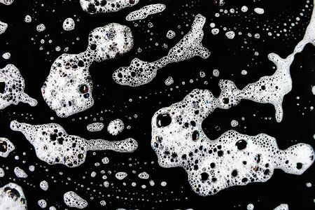 White soap bubbles on a black backgroundの写真素材