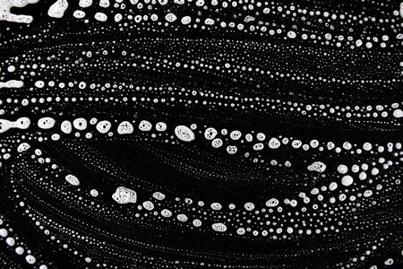 White soap bubbles on a black backgroundの写真素材