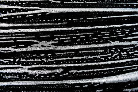 White soap bubbles on a black backgroundの写真素材