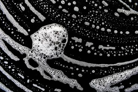 White soap bubbles on a black backgroundの写真素材