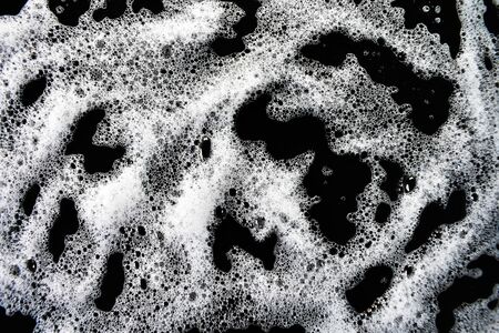 White soap bubbles on a black backgroundの写真素材