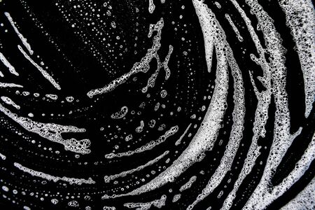 White soap bubbles on a black backgroundの写真素材