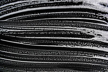 White soap bubbles on a black backgroundの写真素材