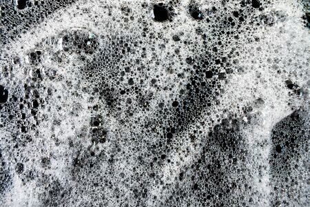 White soap bubbles on a black backgroundの写真素材