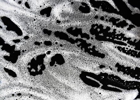 White soap bubbles on a black backgroundの写真素材