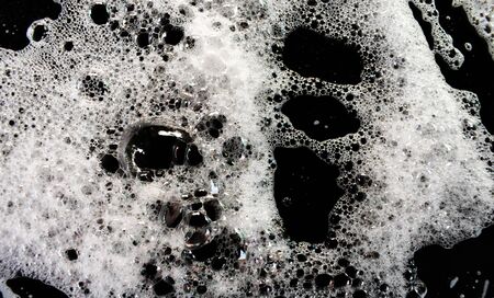 White soap bubbles on a black backgroundの写真素材