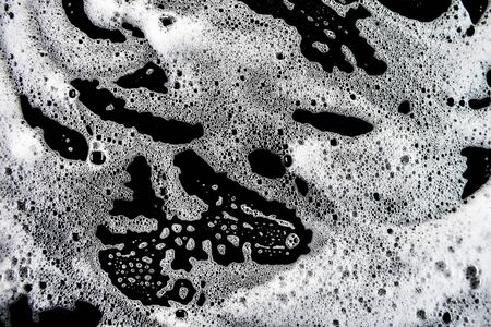 White soap bubbles on a black backgroundの写真素材