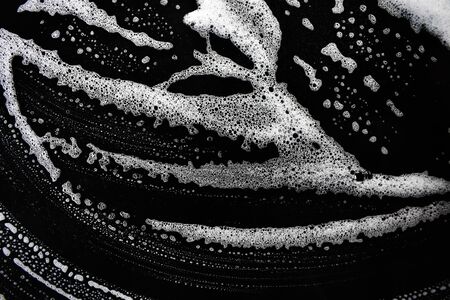 White soap bubbles on a black backgroundの写真素材