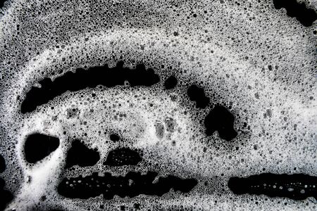 White soap bubbles on a black backgroundの写真素材