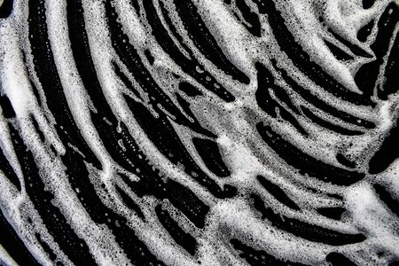 White soap bubbles on a black backgroundの写真素材