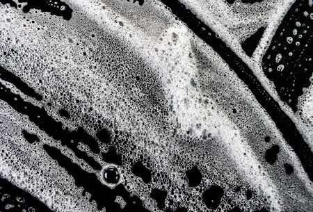 White soap bubbles on a black backgroundの写真素材