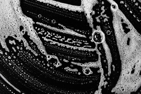 White soap bubbles on a black backgroundの写真素材